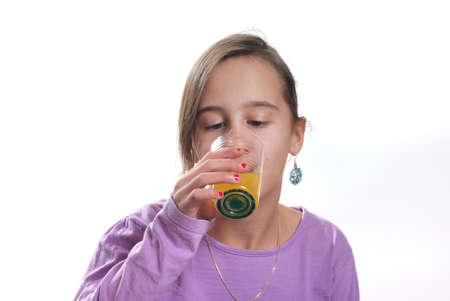 A young girl drinking orange juice glassの写真素材