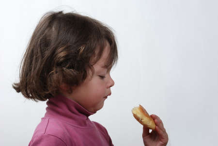 A  young girl eating a bunの写真素材