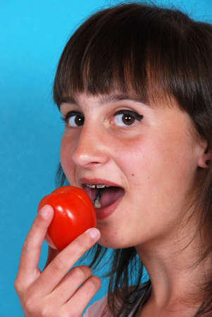 Girl eating a tomatoの写真素材