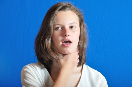 Girl touching her throat.