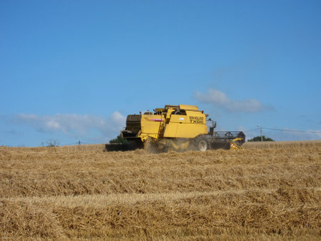 HILLION, FRANCE-AUGUST 13, 2017 straw and combine harvester in harvested field in Hillionのeditorial素材