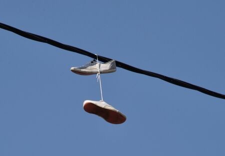 shoes attached to an electric wire by the lacesの写真素材