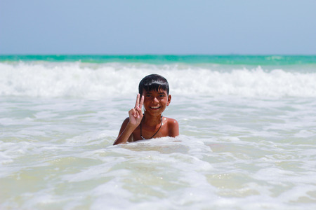 Chonburi, Thailand - July 7: cute smiling boy having fun playing with sea water  on July 7, 2015 Nang-Rum beach, Sattahip, Chonburiのeditorial素材