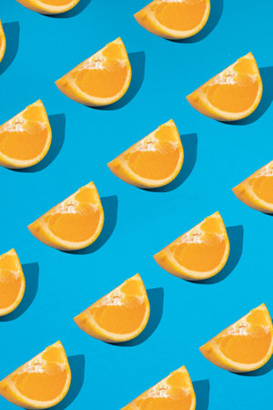 Creative pattern made of slice of orange on a blue background. Flat lay concept.の写真素材