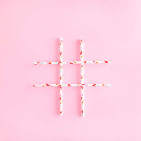 Straws on a pastel pink background. Connection of people on networks. Hashtag sign.の写真素材