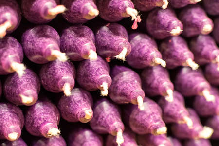 Colorful stick candles with purple tonality, arranged in shelves and sorted by color in a candle shopの写真素材