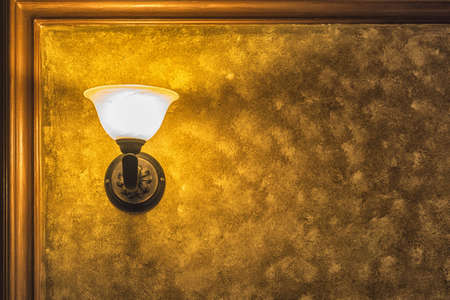 Old vintage lamp on the wall with framed yellow background.の写真素材