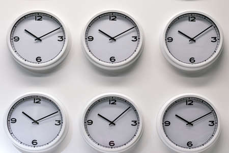 Rows of white plastic wall watches on the white backgroundの写真素材