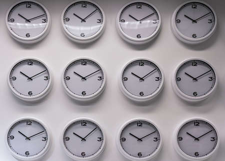 Rows of white plastic wall watches on the white backgroundの写真素材