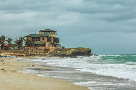 Sea view with storm sky and daylight beach, elite hotel on the rocks, holiday summer concept.の写真素材
