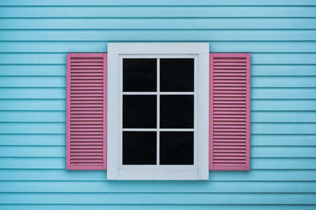 Blue wooden walls and pink windows, rough surfaces and colorful color, the outside of the house is a modern style.の写真素材