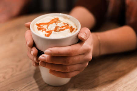 Picture of woman golding cup of coffee with caramelの写真素材