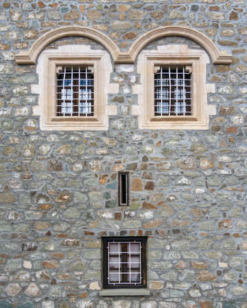 Picture of old vintage concrete castle wall with windows placed like faceの写真素材