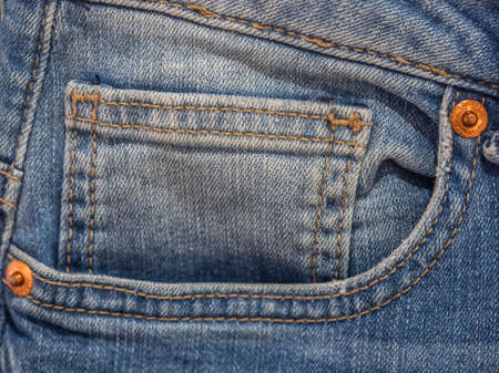 Vibrant blue close up image of waistband of denim jeans with double stitching and metal tack buttonの写真素材