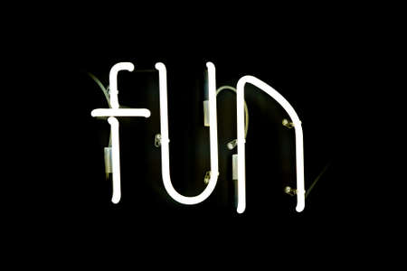 Neon FUN white color sign isolated with black backgroundの写真素材