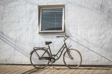 Retro bicycle on roadside with vintage concrete wall backgroundの写真素材