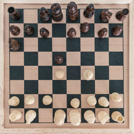 Top view on wooden chess board with chess figures ready for the game