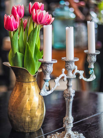 Purple tulips in metal vase with candles on wooden background.の写真素材