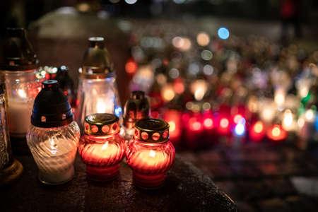 Jars with burning candles on stone surface at nightの写真素材