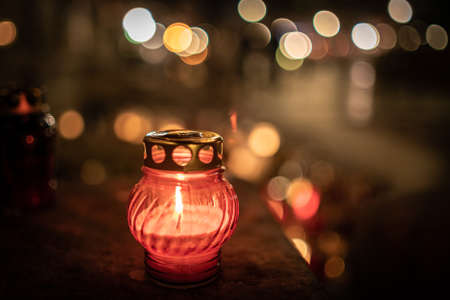 Jars with burning candles on stone surface at nightの写真素材