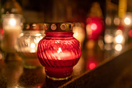 Jars with burning candles on stone surface at nightの写真素材