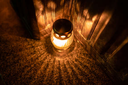 Jars with burning candles on stone surface at nightの写真素材