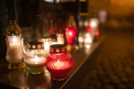 Jars with burning candles on stone surface at nightの写真素材
