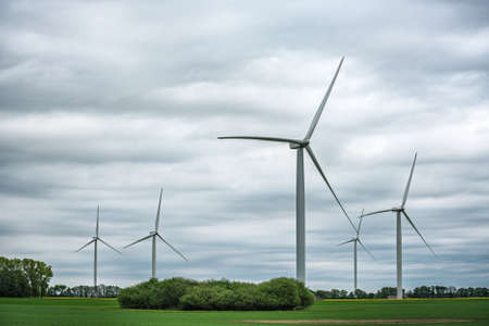 Image of Wind turbines on the green field at cloudy dayの写真素材