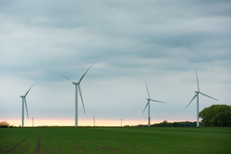 Image of Wind turbines on the green field at cloudy dayの写真素材