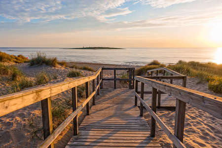Image of Wooden path at Baltic sea over sand dunes with ocean view, sunset summer eveningの写真素材