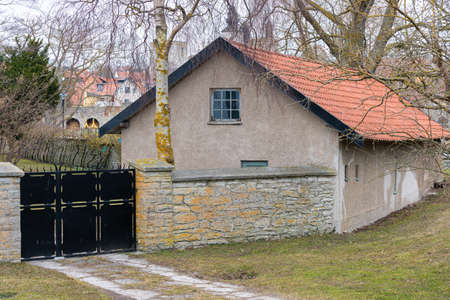 Image of Old scandinavian concrete village house with metal entrance gatesの写真素材