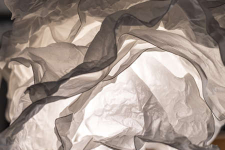 Close up image of white fabric crumpled blanket texture with light source behind