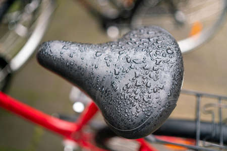 Wet black seat Bicycle saddle with rain water drops.の写真素材