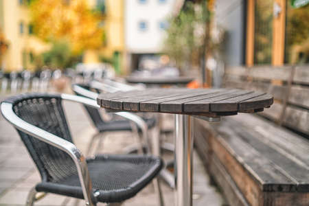 Wooden tables on narrow street among typical colorful houses and small bridge in Sweden
