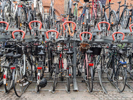 Row of city parked bicycles bikes for rent on sidewalk. Bike Bicycle Parking In European Cityの写真素材