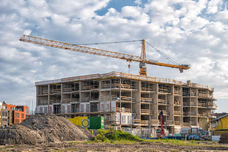 Image of Construction of a house with a yellow tower crane on blue sky backgroundの写真素材