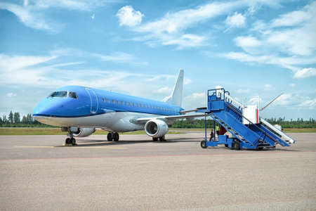Airplane near the terminal in an airport at the sunsetの写真素材
