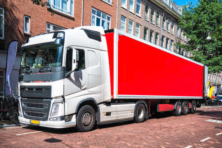 Front View of Semi-Truck with Red Cargo Trailer Driving on the street.の写真素材