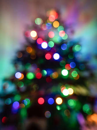 defocused picture of christmas tree with colorful lights on itの写真素材