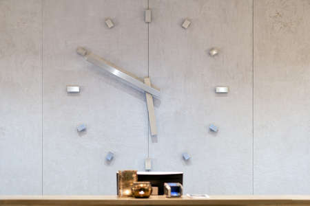 Reception desk in hotel with giant clock at the backgroundの写真素材