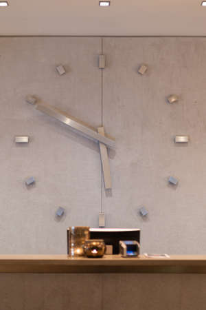 Reception desk in hotel with giant clock at the backgroundの写真素材