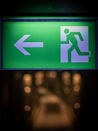 green emergency exit sign in hotel showing the way to escape