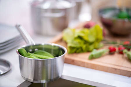 image of aluminium pot with vegetables on the kitchen tableの写真素材
