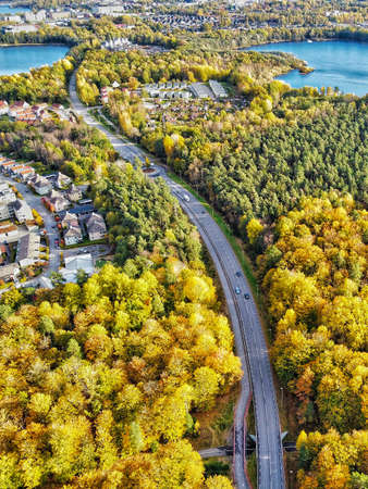 Aerial image of the road between two lakes and autumn triesの写真素材