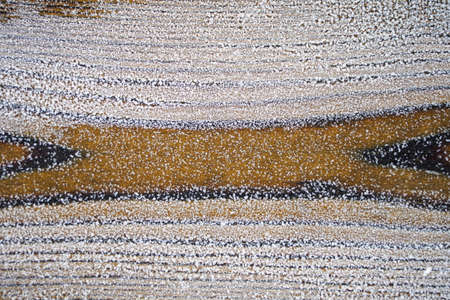 Frozen and covered with ice wooden surface