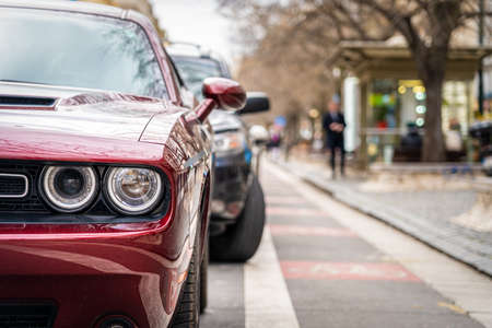 Sport car parked in a row on a city street side.の写真素材