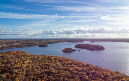 Image of Aerial view of orange autumn forest with blue lake in Sweden.の写真素材