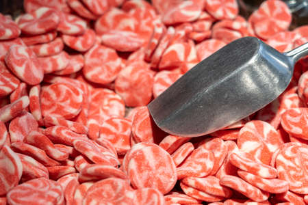 Red sweet candies in a candy store with metal scoop