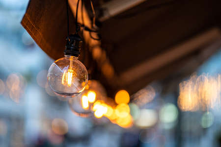 Light bulbs hanging for decoration at the bar on daylightの写真素材
