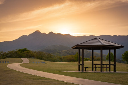 A beautiful place to relax with a wonderful view of the mountains at sunset. Wooden pergola with benchesの写真素材